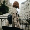 shallow focus photography of woman beside fence