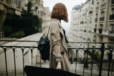 shallow focus photography of woman beside fence