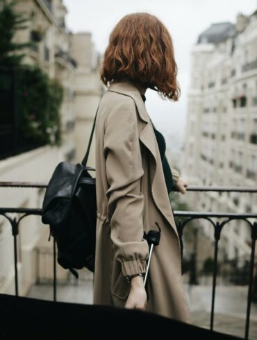shallow focus photography of woman beside fence