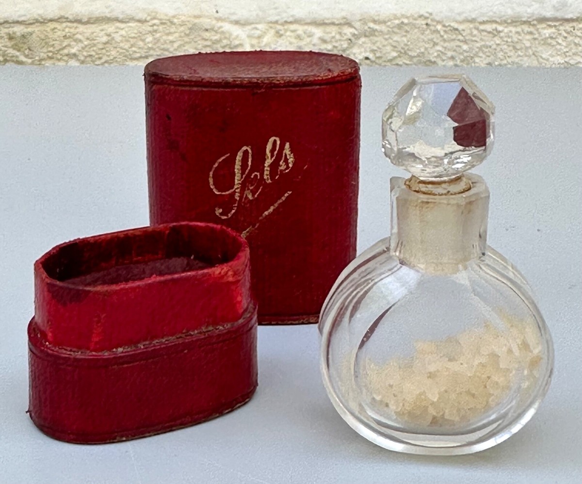 crystal perfume bottle resting on an antique leather