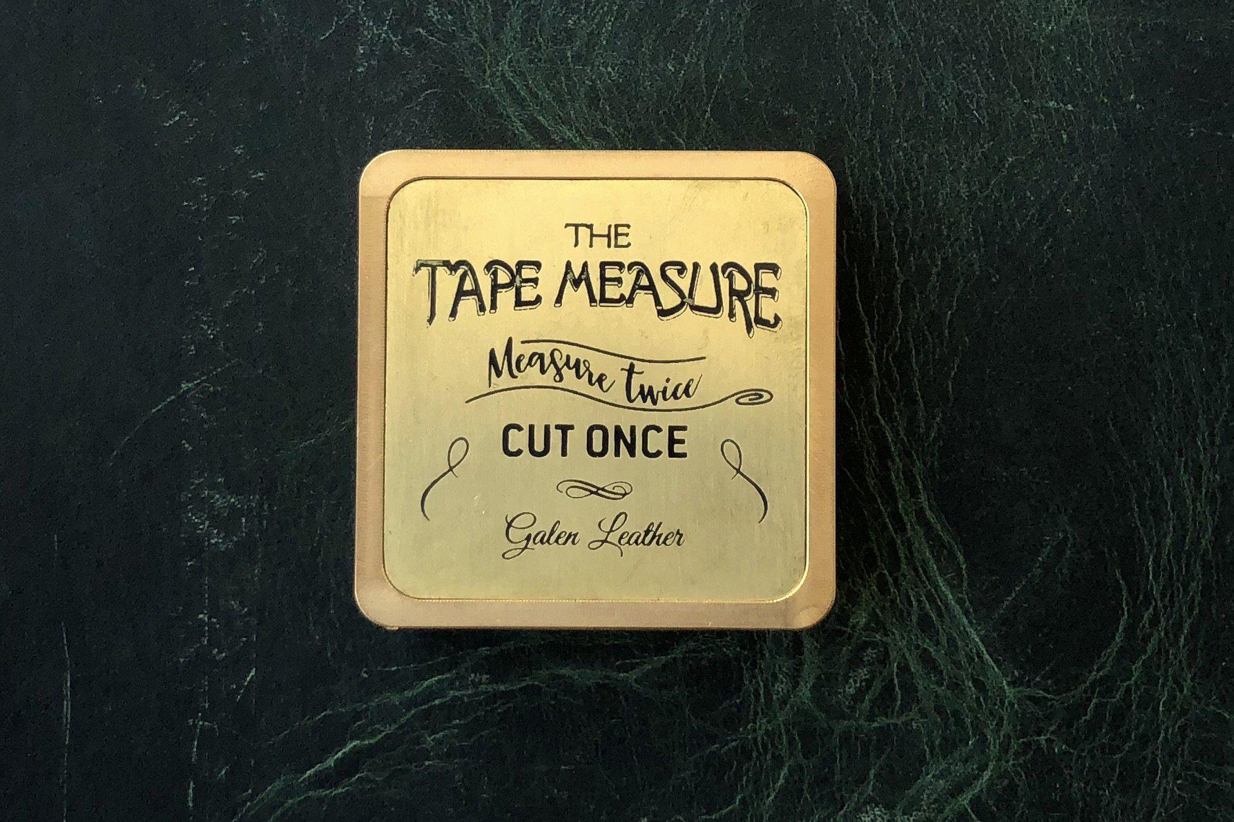 brass measuring tape on wooden picture frame