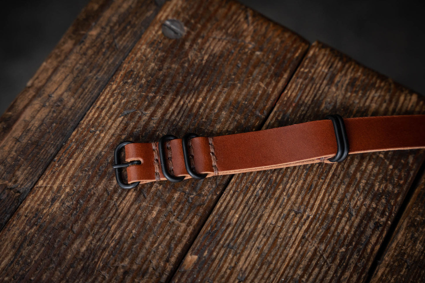close-up of hand-stitched leather straps and brass hardware
