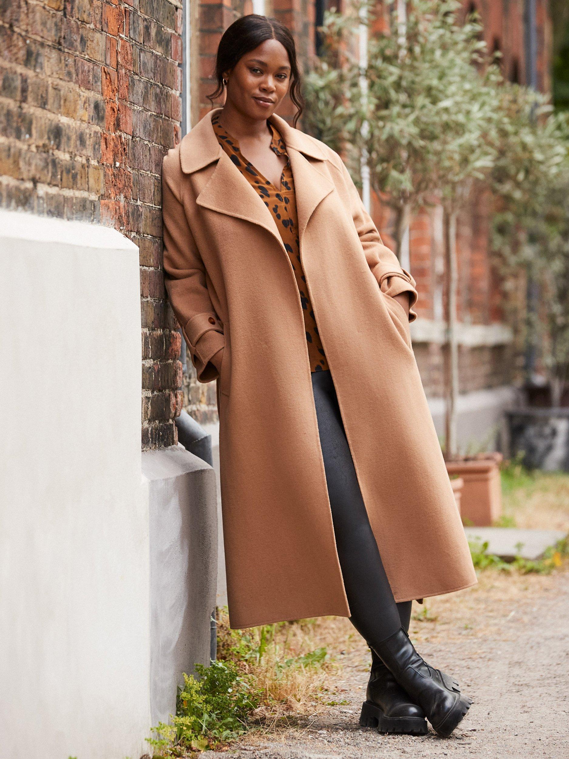 dark camel cashmere coat draped over velvet living