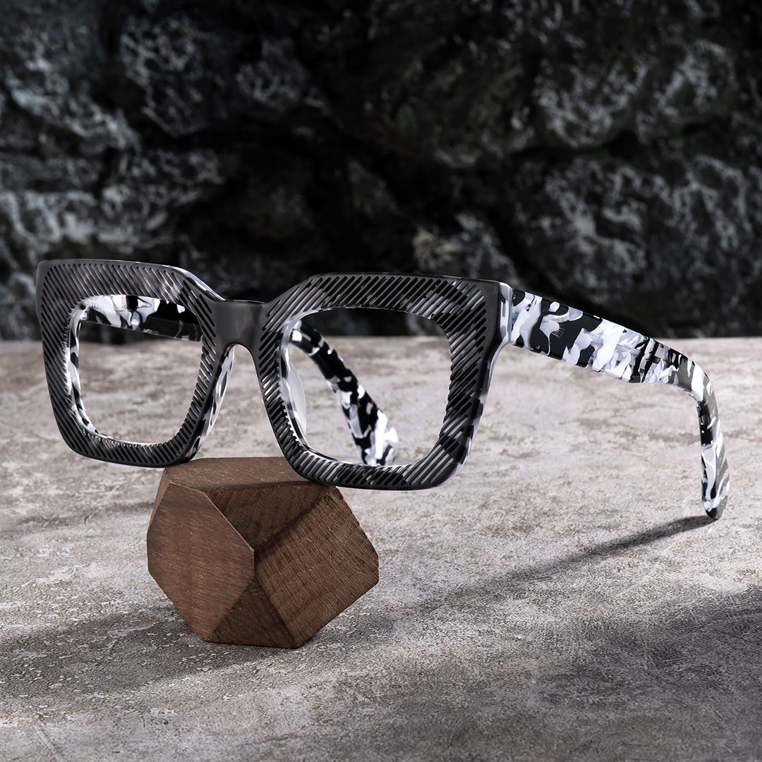 thick black geometric glasses frame on white marble